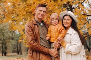 Father and mother with son walking in the autumn Park. A family walks in the Golden autumn in a nature Park. photo