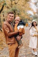 Father and mother with son walking in the autumn Park. A family walks in the Golden autumn in a nature Park. photo