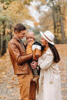 Father and mother with son walking in the autumn Park. A family walks in the Golden autumn in a nature Park. photo