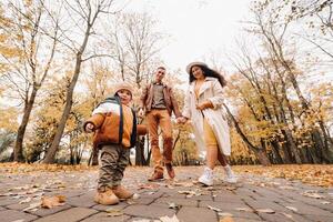 Father and mother with son walking in the autumn Park. A family walks in the Golden autumn in a nature Park. photo
