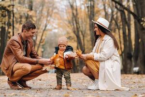 Father and mother with son walking in the autumn Park. A family walks in the Golden autumn in a nature Park. photo