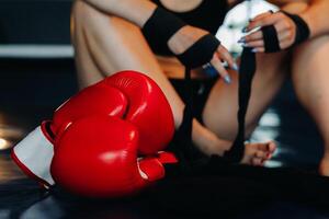 Close-up of red boxing gloves on the floor of a blue boxing ring photo