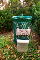 Trash can with a picture of a dog and bags for excrement photo