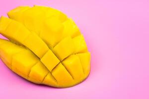 Fresh ripe mango on a pink background. Half a sliced mango on a pink background photo