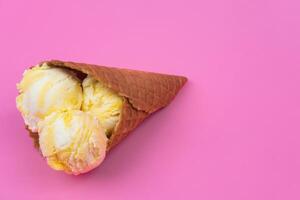 Fruit-scented ice cream balls in a waffle cone on a pink background. photo