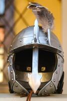 An ancient knight's helmet with a feather .Medieval concept photo