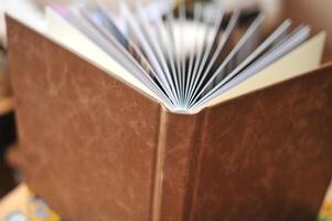 Composition of photobooks in natural brown leather . Fragment of a photobook binding photo