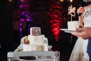 The bride and groom cut their wedding cake. beautiful cake with a cut and visible filling. wedding cake with the word love,the concept of the wedding photo