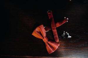 Red bow Tie on a dark background and cufflinks.wedding concept photo