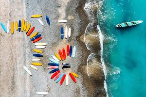 a beautiful couple is lying on the beach of France next to surfboards, shooting from a quadcopter, a lot of surfboards are unusually lying on the beach photo