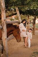 A pregnant woman with her son walks in the countryside in the summer photo