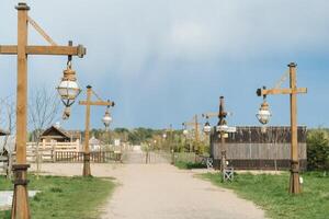 Old wooden lanterns hanging on a wooden pole along the road photo