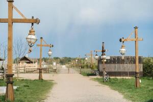 Old wooden lanterns hanging on a wooden pole along the road photo