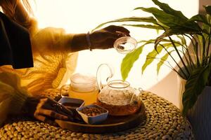 A teapot with sea buckthorn tea, honey and a plate with sea buckthorn on a tray photo