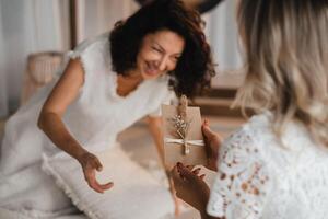 A woman in white clothes passes an envelope with a wish to another woman. The concept of the women's circle photo