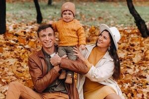 Father and mother with son walking in the autumn Park. A family walks in the Golden autumn in a nature Park. photo
