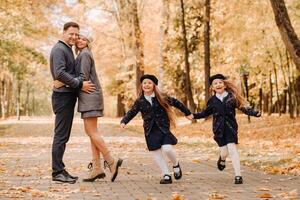 A large family walks in the park in the fall. Happy people in the autumn park photo
