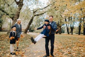 A large family walks in the park in the fall. Happy people in the autumn park photo