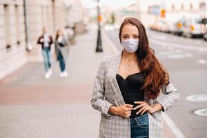Covid-19 and Air pollution pm2.5 concept. Pandemic, portrait of a young woman wearing protective mask on street. Concept health and safety. photo