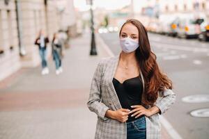 Covid-19 and Air pollution pm2.5 concept. Pandemic, portrait of a young woman wearing protective mask on street. Concept health and safety. photo