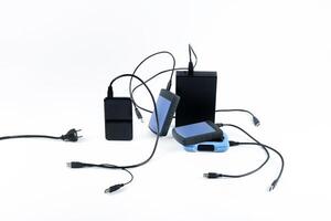 many external hard drives with wires lie on a white background. Hard drives on isolate. photo