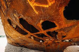 Rusted with holes, the ship is on the sea shore.Rusty ship in the Bay of Navagio on the island of Zakynthos photo