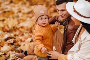 Father and mother with son walking in the autumn Park. A family walks in the Golden autumn in a nature Park. photo
