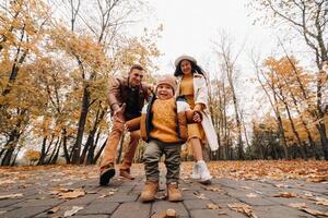 Father and mother with son walking in the autumn Park. A family walks in the Golden autumn in a nature Park. photo