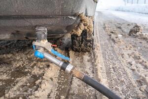Filling the car from the bottom of the bumper with gas in the winter at the gas station photo