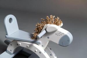 Handmade rocking horse on a gray background photo