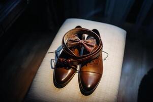 a red bow tie sits on a shelf with a belt and boots photo