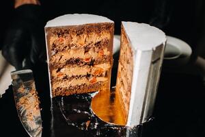 Amazing Cakes. Sliced chocolate wedding cake cake with amazing filling on a black background.Large cake in white chocolate photo