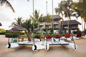 catamarans with sails are parked on the beach in front of a villa on the tropical island of Mauritius photo