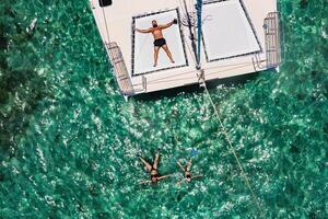 a young handsome man is lying on a yacht in the Indian ocean next to his family swimming in masks.Mauritius island photo