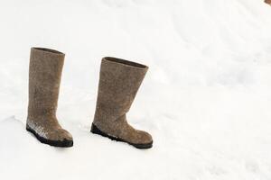 close up of felt boots standing in the snow photo