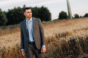 Portrait of a businessman in a gray suit in a wheat field.A man in nature in a jacket and tie photo