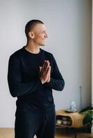 An athletically built man does yoga in the gym on a mat photo