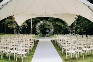 Wedding ceremony on the street on the green lawn.Decor with fresh flowers arches for the ceremony photo