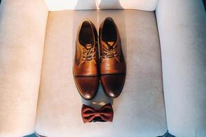 brown bow tie on a light background and boots. photo
