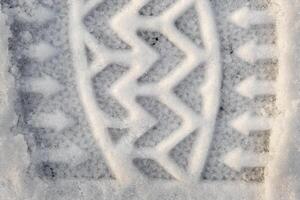 Close-up of a shoe print in the snow, top view of a boot footprint photo
