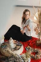 Women's circle and practice in the use of metaphorical cards. The girl is sitting surrounded by flowers photo