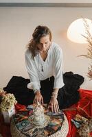 Women's circle and practice in the use of metaphorical cards. The girl is sitting surrounded by flowers photo