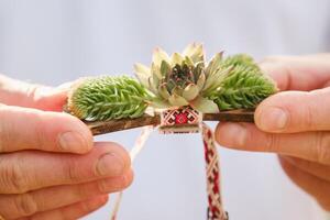 Close-up of hands holding a bow tie with decorative flowers on it photo