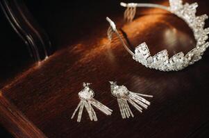 Wedding crown for the bride and earrings lie on the trellis photo