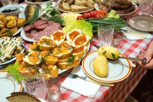 A lot of different food on the Banquet table and served boiled potatoes with dill.A large number of ready-made dishes on the table.Holiday at the table photo