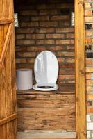 A simple village toilet with a huge roll of toilet paper.Large roll of toilet paper in the toilet photo