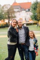 A happy family of three runs through the grass in Austria's old town.A family walks through a small town in Austria.Europe.Velden am werten Zee photo