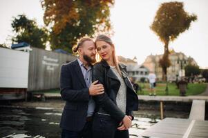 a family of two stands on a pier in Austria's old town at sunset .A man and a woman embrace on the embankment of a small town in Austria.Europe.Felden am Werten see photo