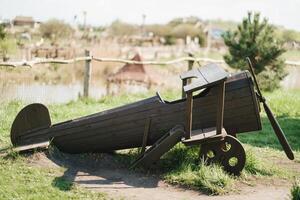 A wooden model of an airplane standing on the street in summer photo