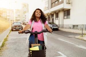 A cheerful lady with curly hair enjoys riding her bicycle along a city street. The sun shines brightly as she navigates past parked cars and buildings, showcasing her playful spirit. photo